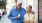 older couple walks down city sidewalk while holding ice cream cones